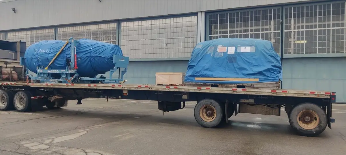 Two jet engines tarped on a Trans Link flatbed